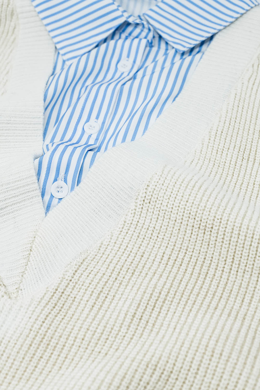 camisa listrada azul e suéter em uma peça
