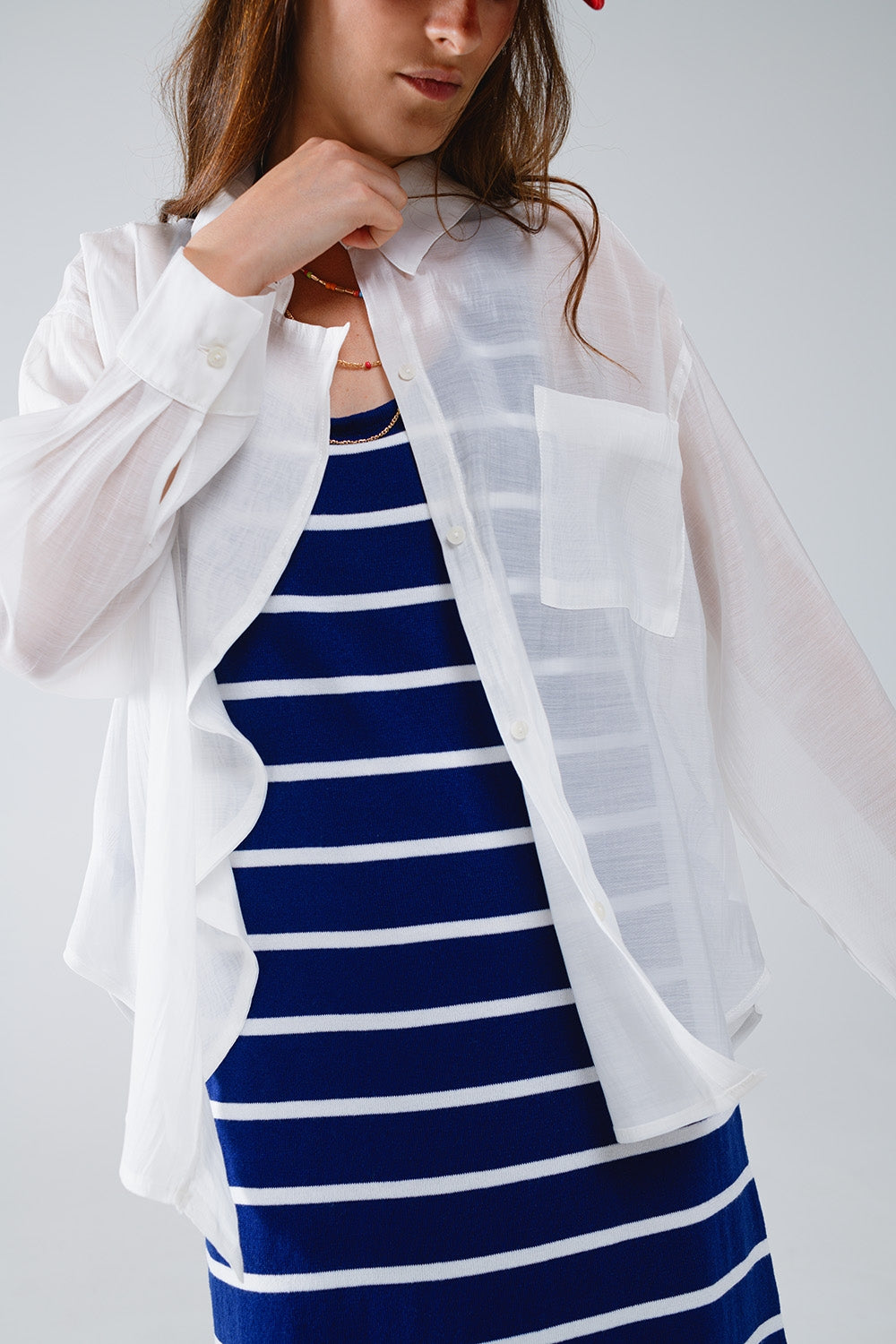 Blusa branca semi-transparente com detalhes de folhos na frente