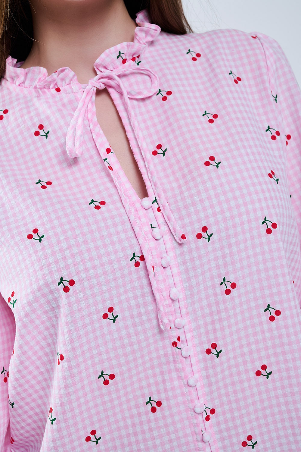 Blusa cor-de-rosa com detalhes de cerejas e laço atado