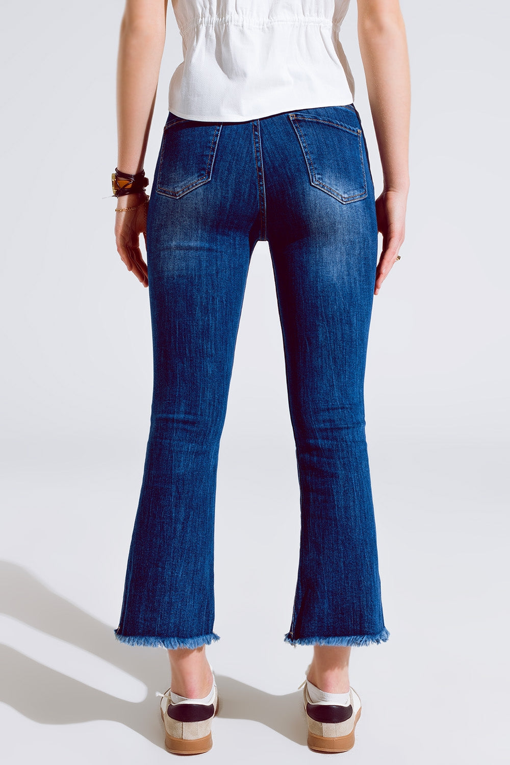 Calças de ganga skinny com bainha crua em lavagem média