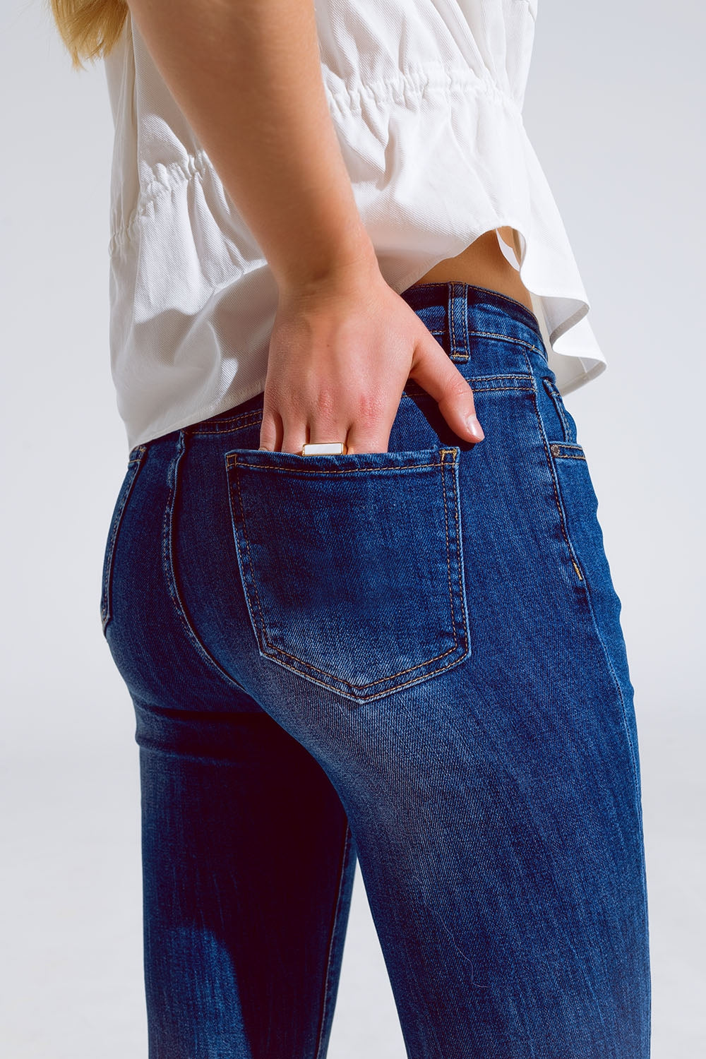 Calças de ganga skinny com bainha crua em lavagem média