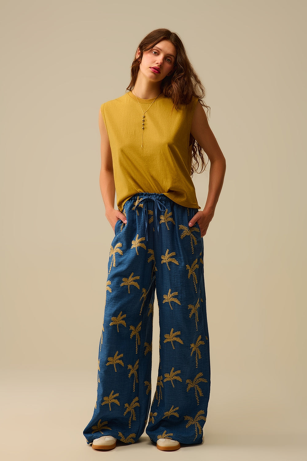 Calça de perna larga azul com bordado de palmeira bege