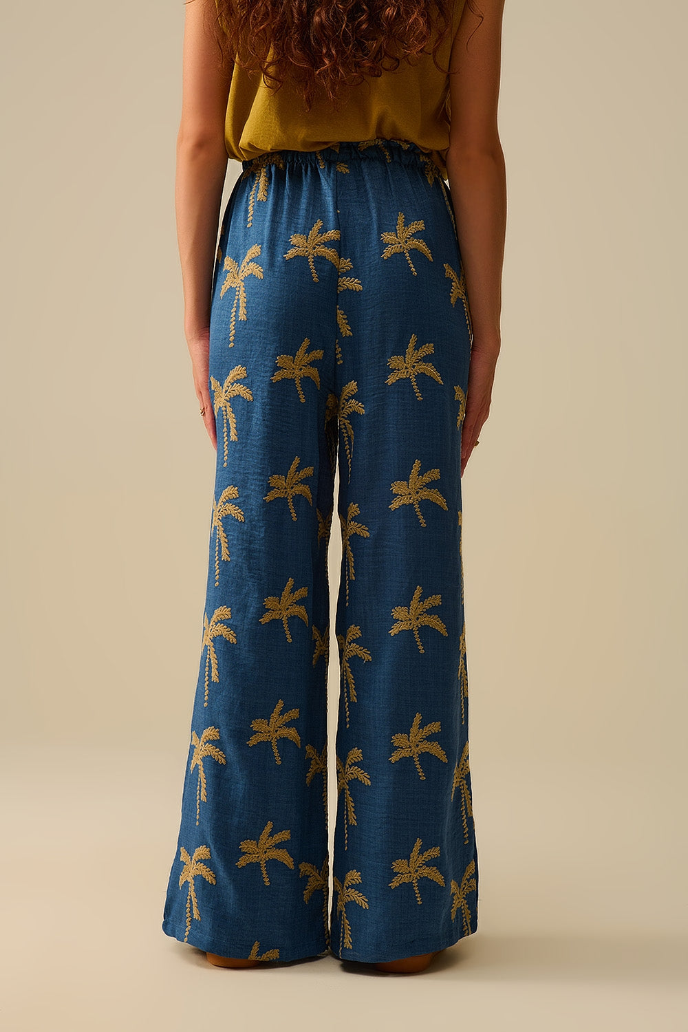Calça de perna larga azul com bordado de palmeira bege