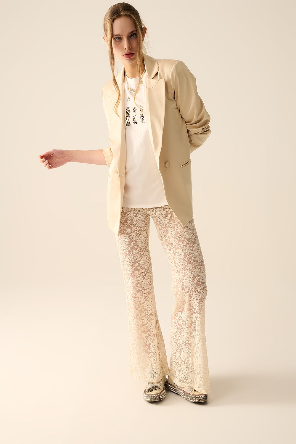 Calça flare de creme em renda floral