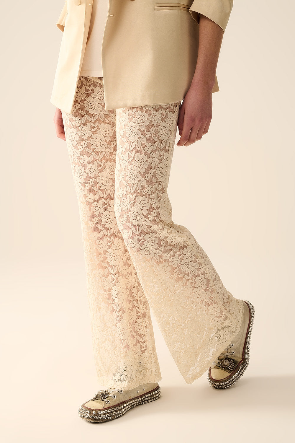 Calça flare de creme em renda floral