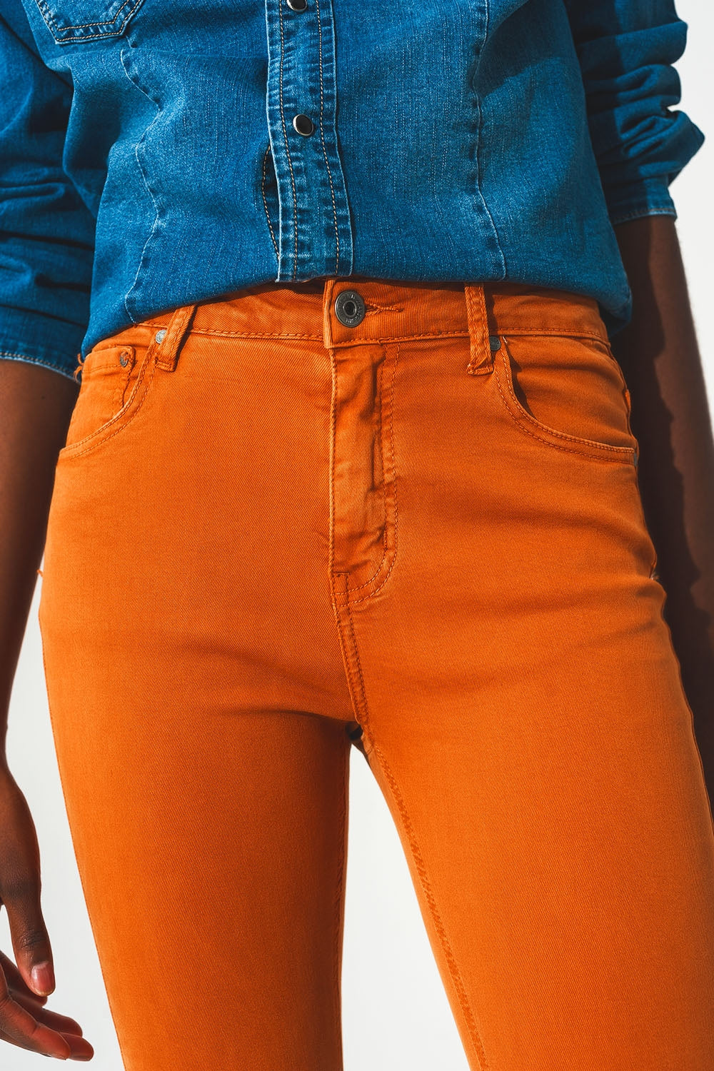 Calça jeans flare com bainha desfiada em laranja