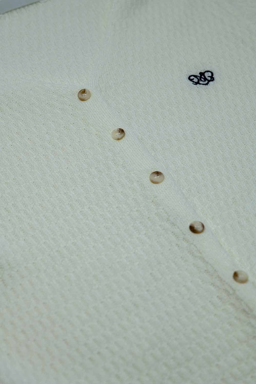Casaco de malha branco com mangas curtas e fecho frontal com botão
