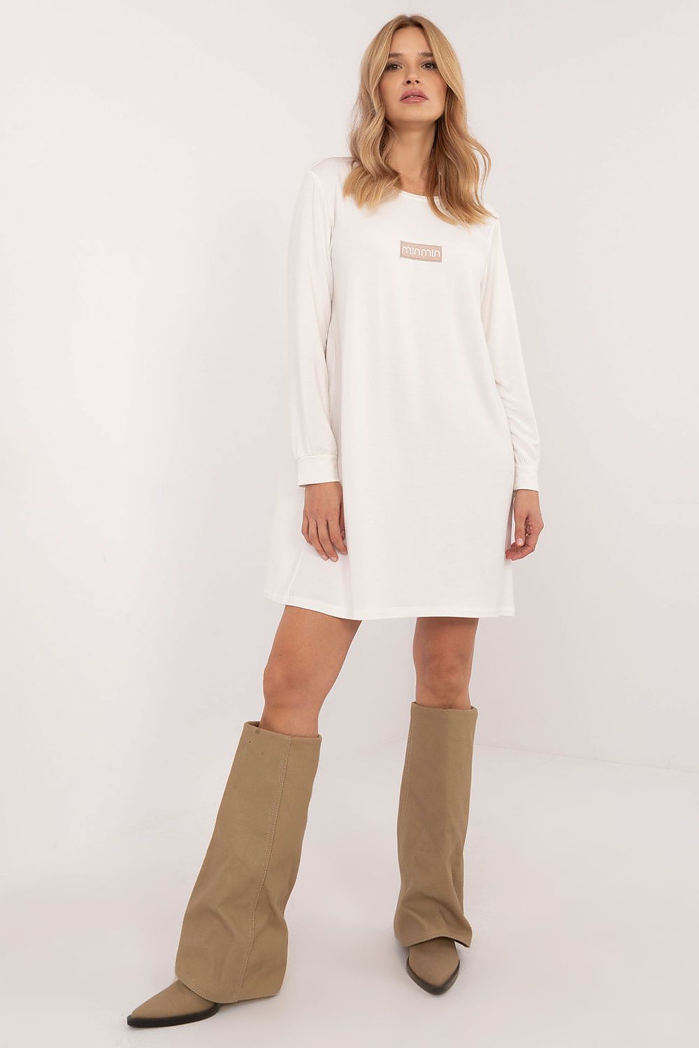 White casual oversized mini dress by Relevance worn with tan knee-high boots