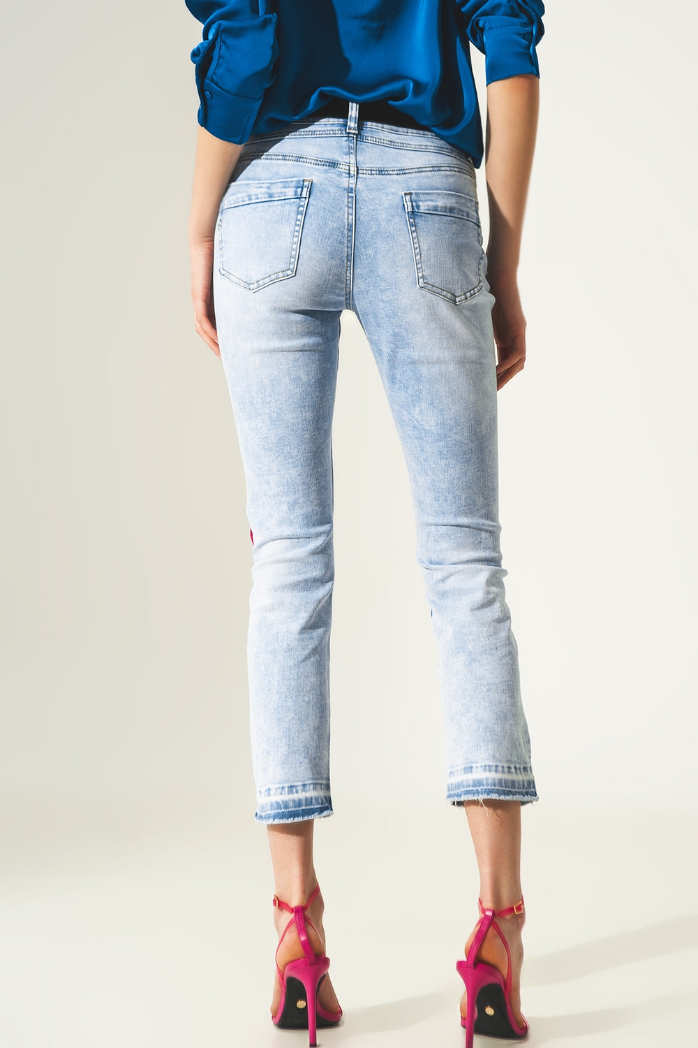 Jeans reto desgastado com detalhe na bainha em azul