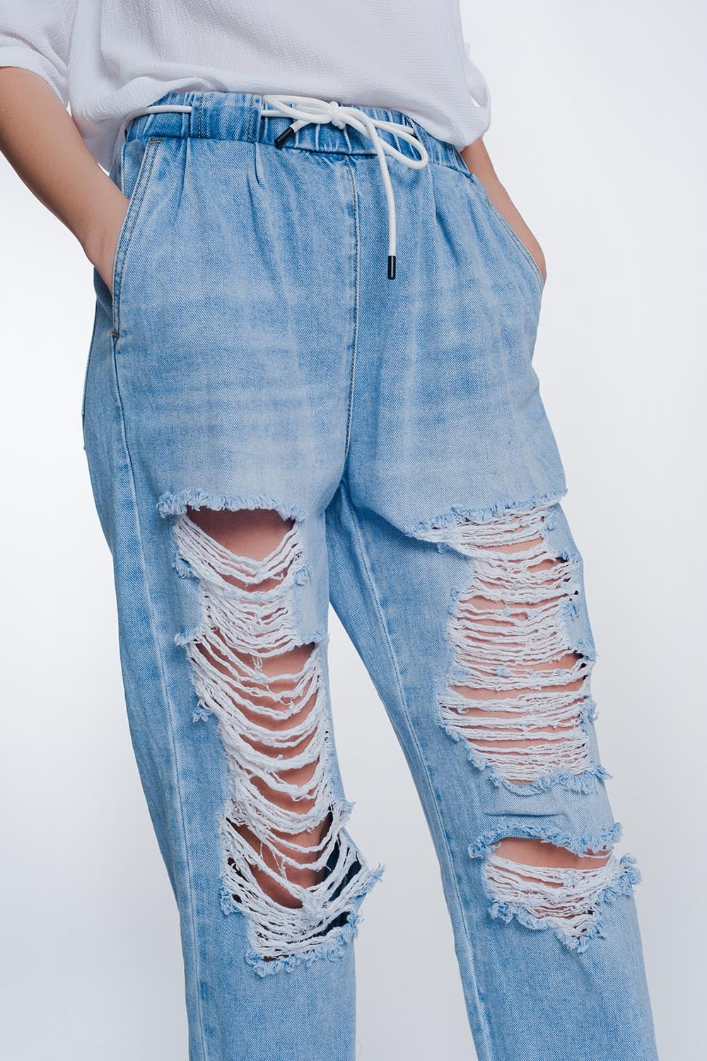 Calça jeans boyfriend muito rasgada em denim claro