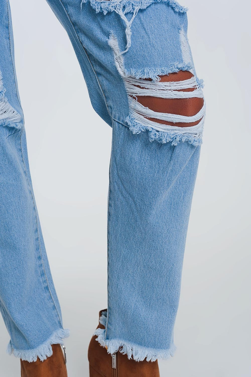 Calça mom jeans de cintura alta com joelhos estourados em jeans claro