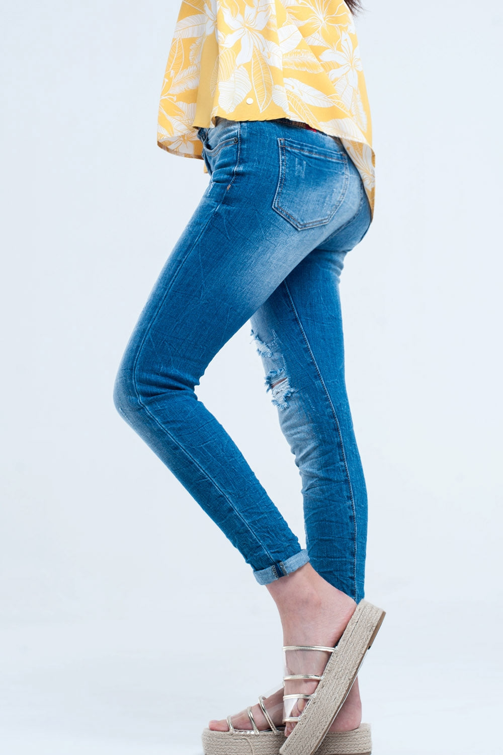 Jeans justo com lavagem média e rasgos