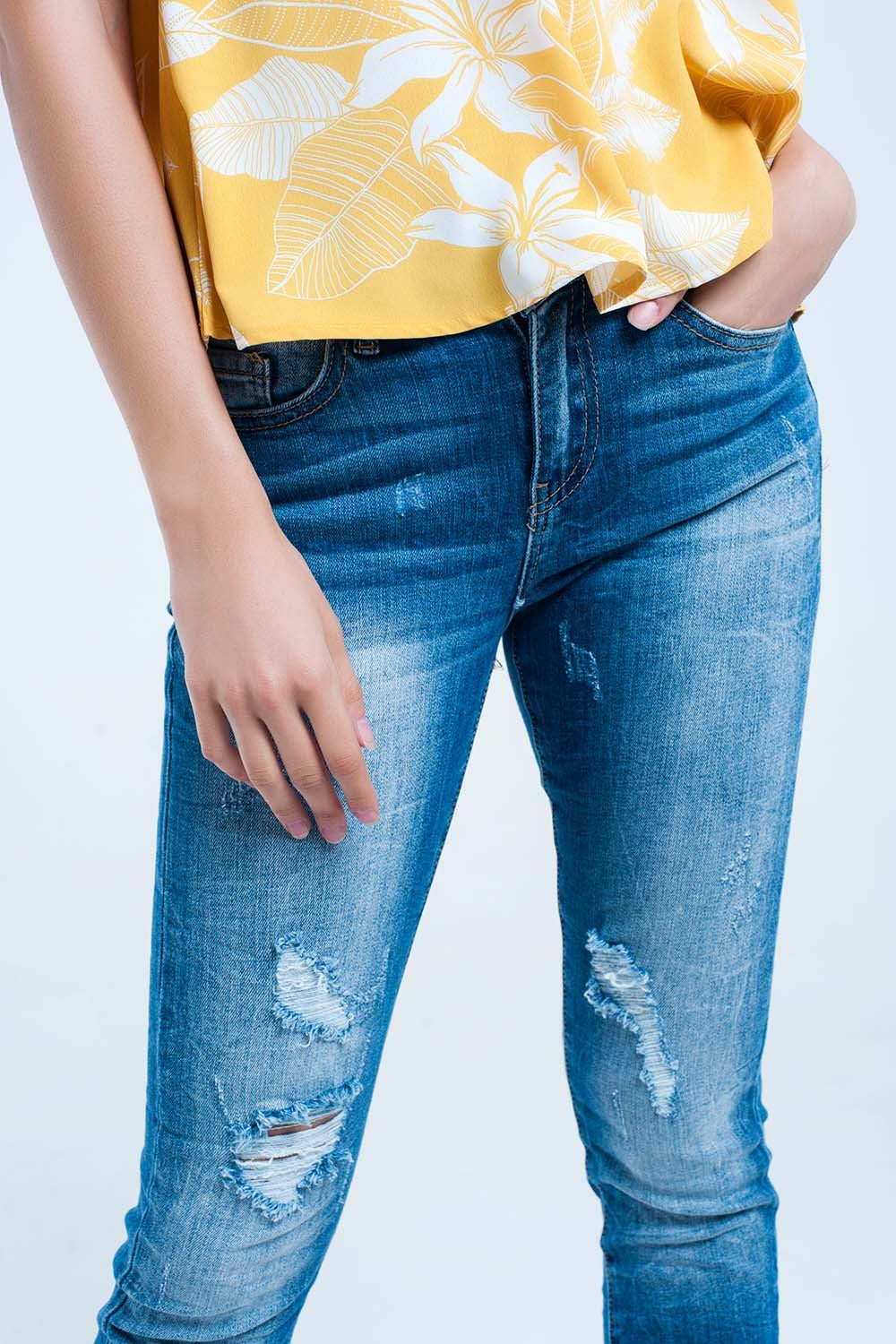 Jeans justo com lavagem média e rasgos