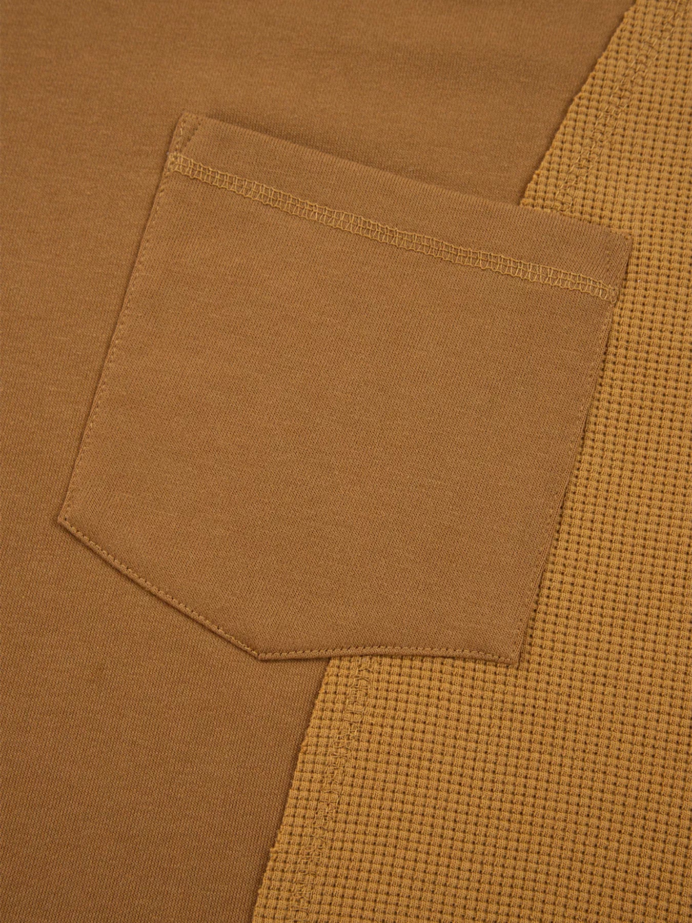 Close-up of Oversized Textured Split Neck High Low Sweatshirt featuring a pocket detail in a warm brown tone