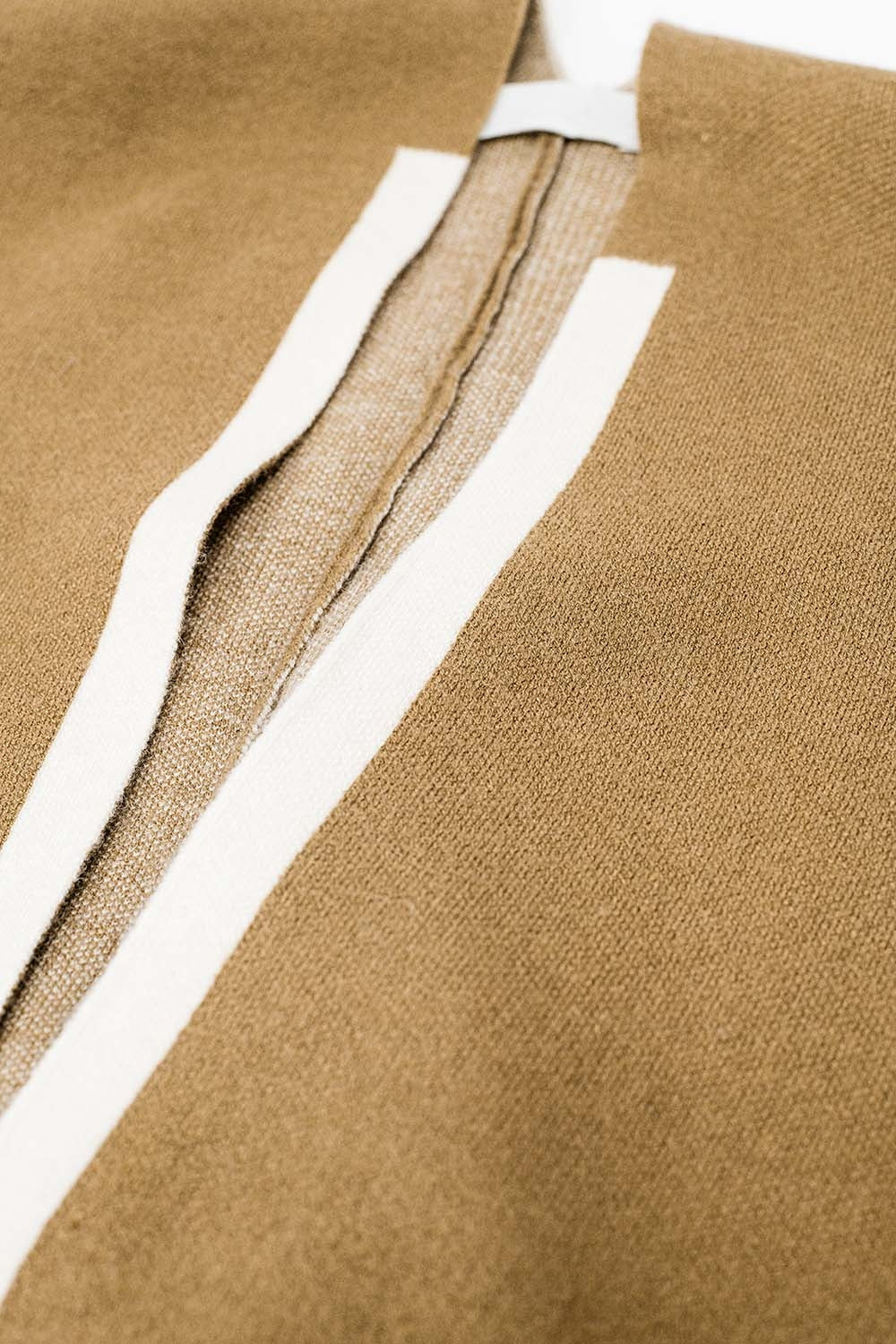 Poncho de malha em camelo com acabamento em cru
