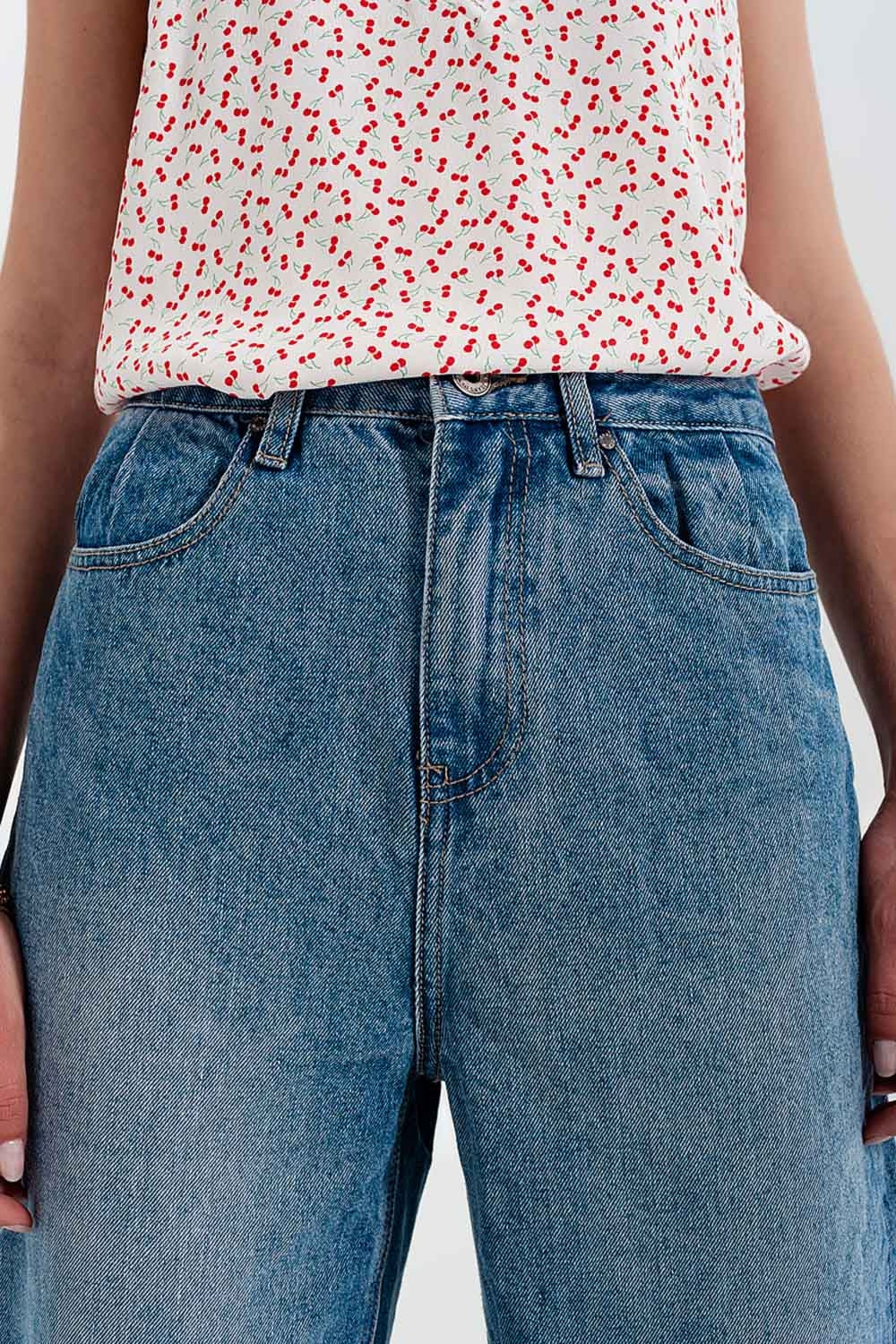 Jeans com rasgos laterais e corte relaxado em azul médio