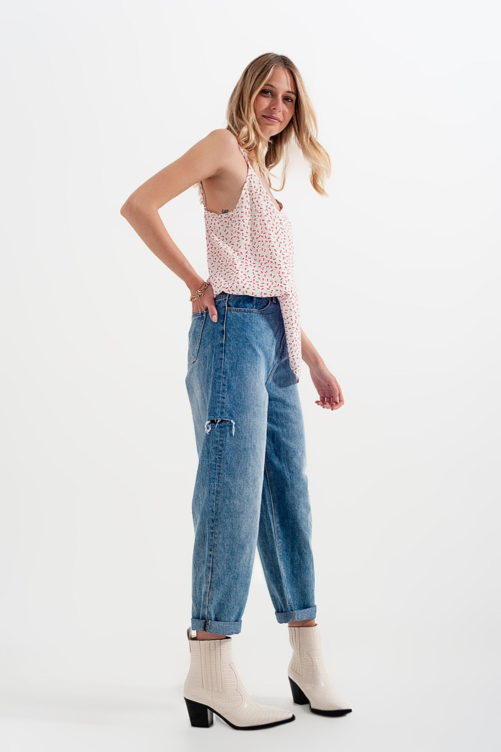 Jeans com rasgos laterais e corte relaxado em azul médio