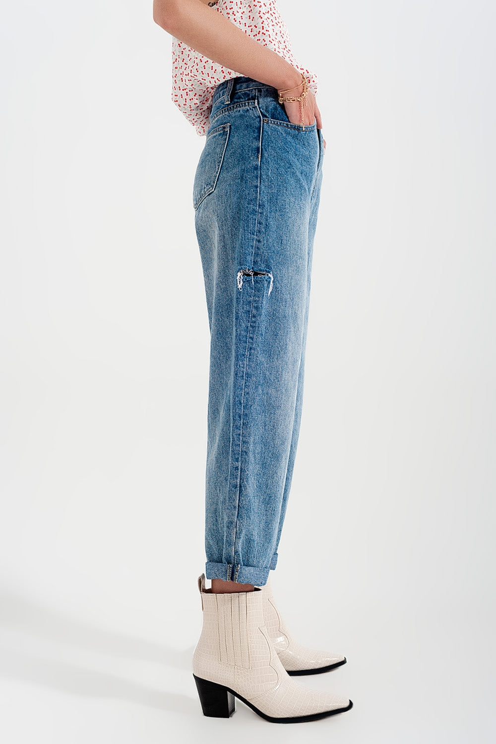 Jeans com rasgos laterais e corte relaxado em azul médio