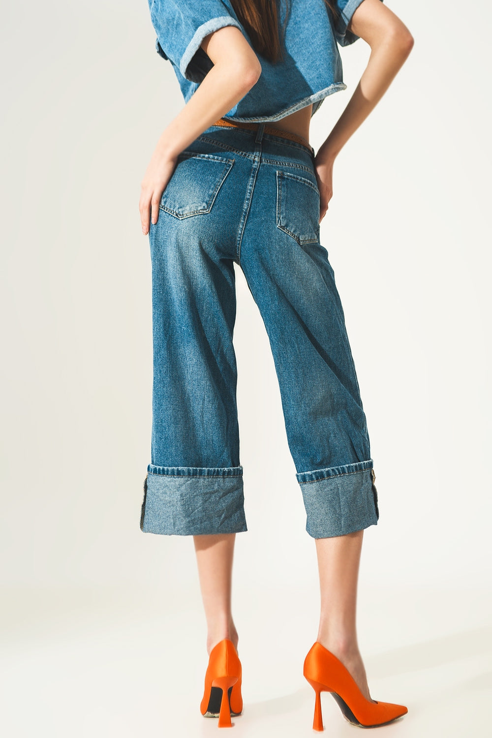 Jeans relaxado com bainha enrolada e botões expostos em azul