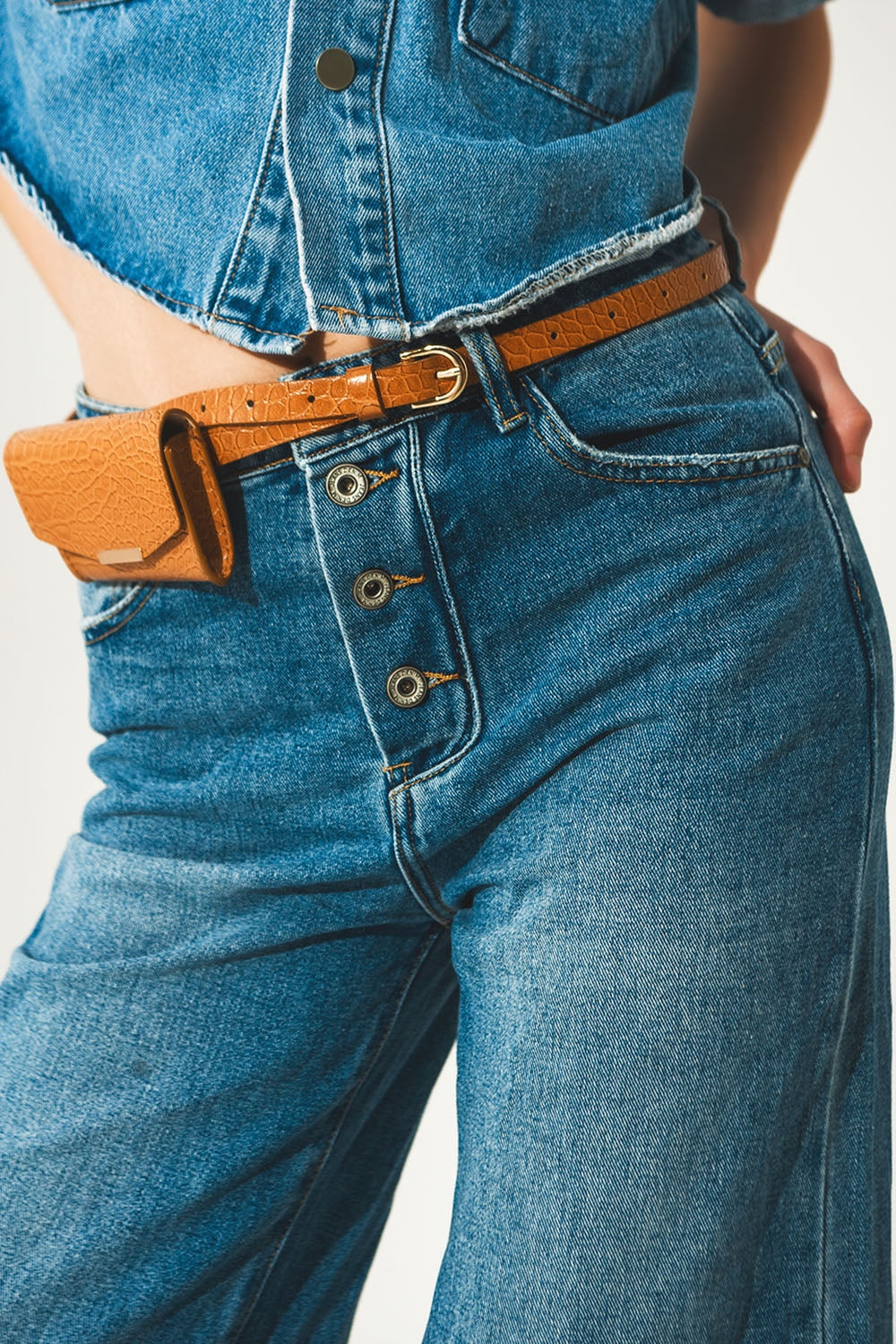 Jeans relaxado com bainha enrolada e botões expostos em azul