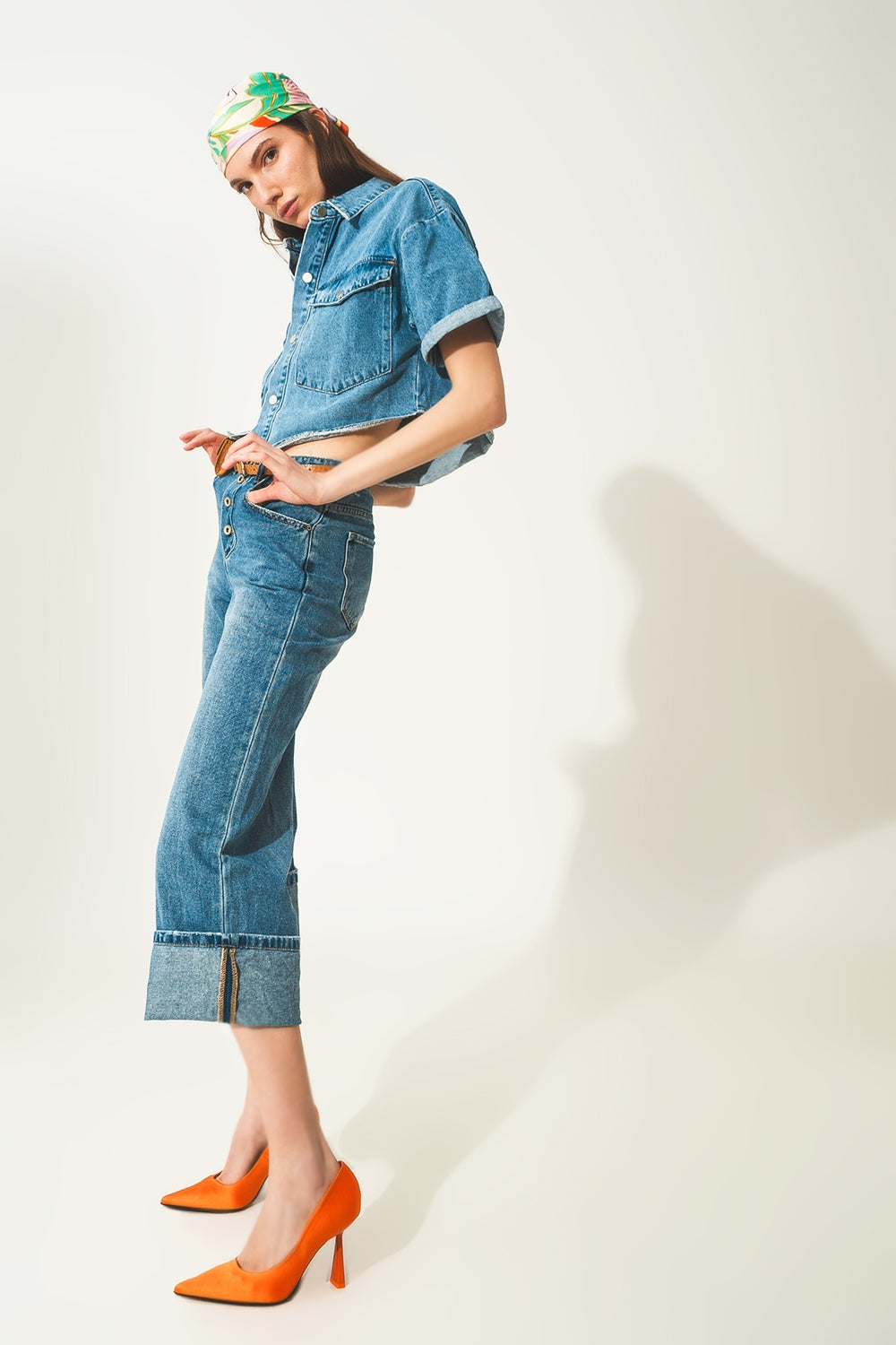 Jeans relaxado com bainha enrolada e botões expostos em azul