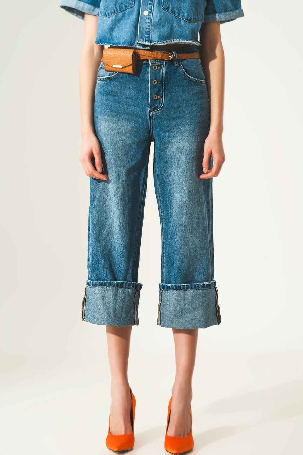 Jeans relaxado com bainha enrolada e botões expostos em azul