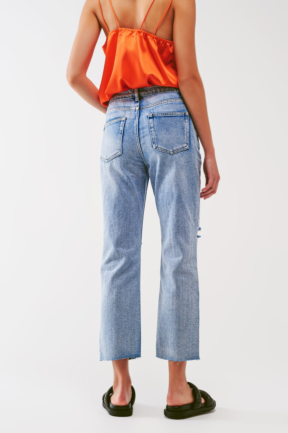 Jeans reto com botões aparentes e joelhos rasgados em lavagem clara
