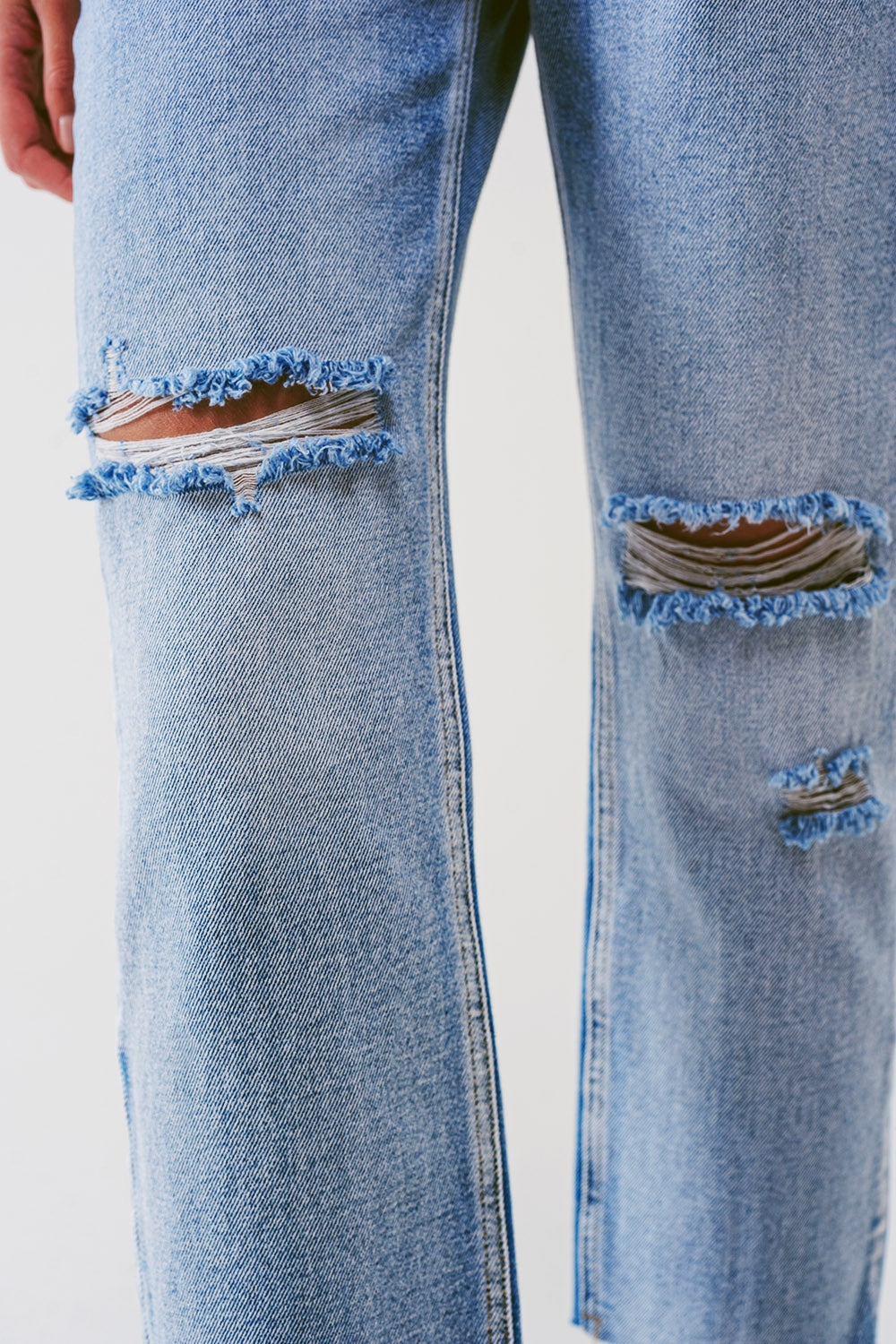 Jeans reto com botões aparentes e joelhos rasgados em lavagem clara