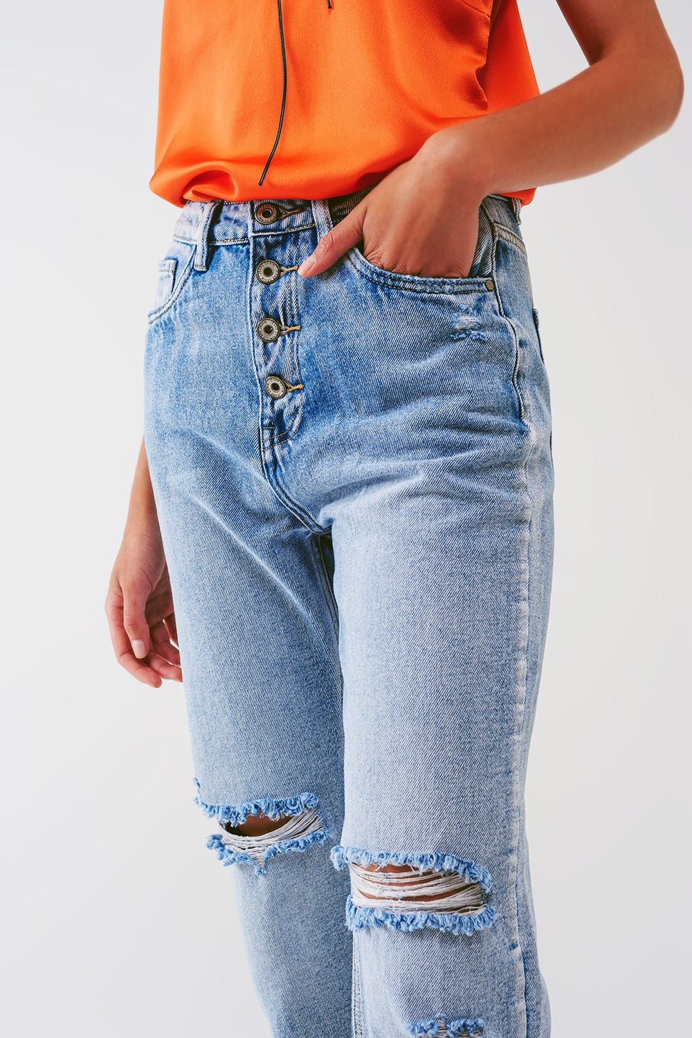 Jeans reto com botões aparentes e joelhos rasgados em lavagem clara