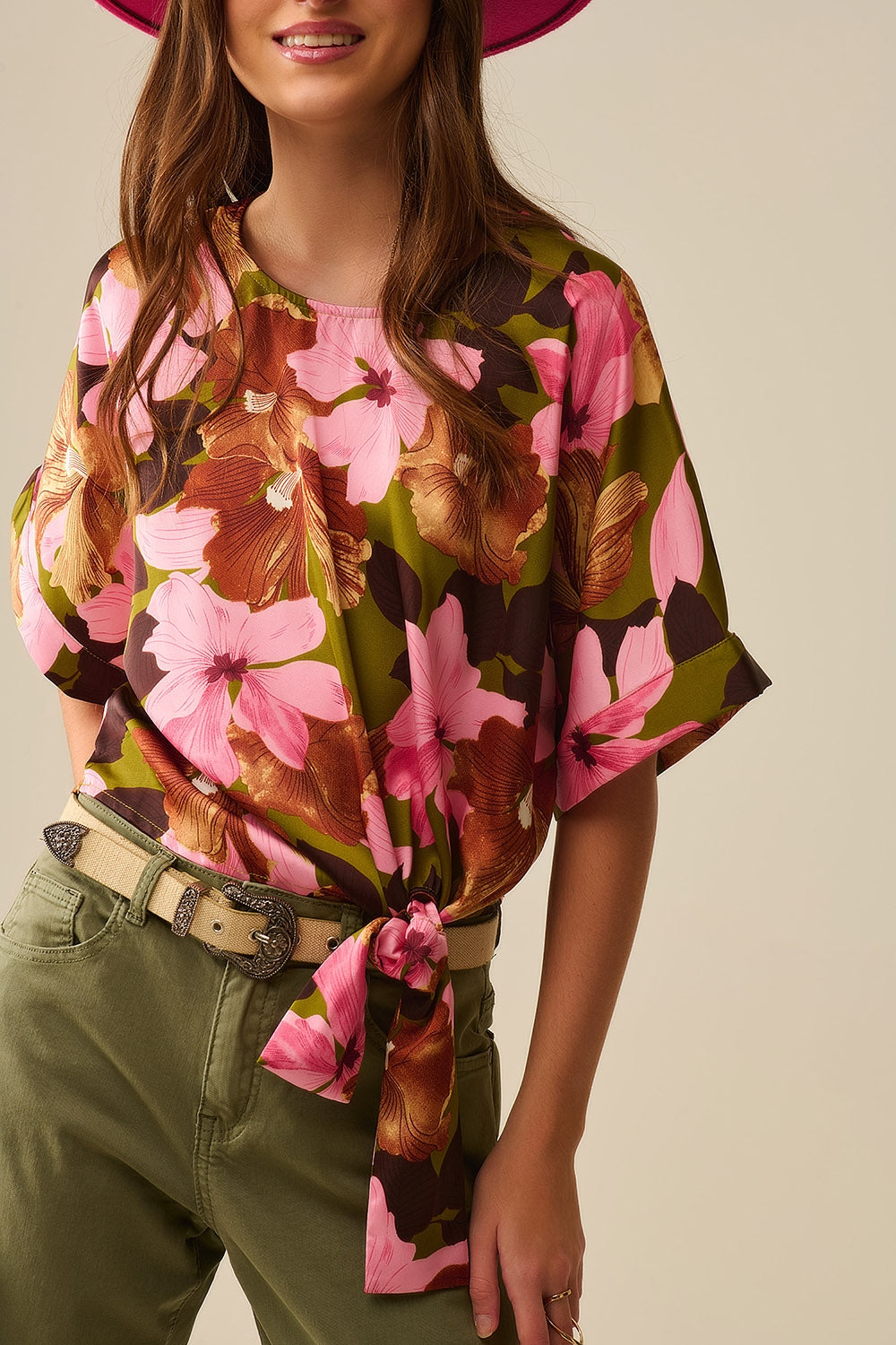 Top com nó floral e fundo verde em tecido acetinado