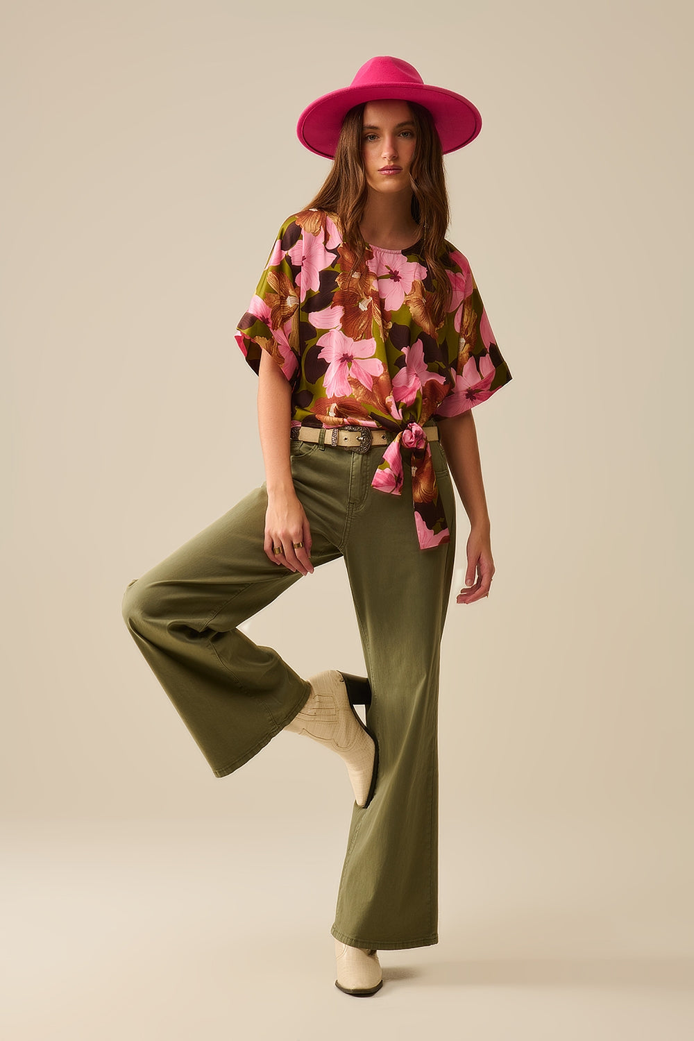 Top com nó floral e fundo verde em tecido acetinado