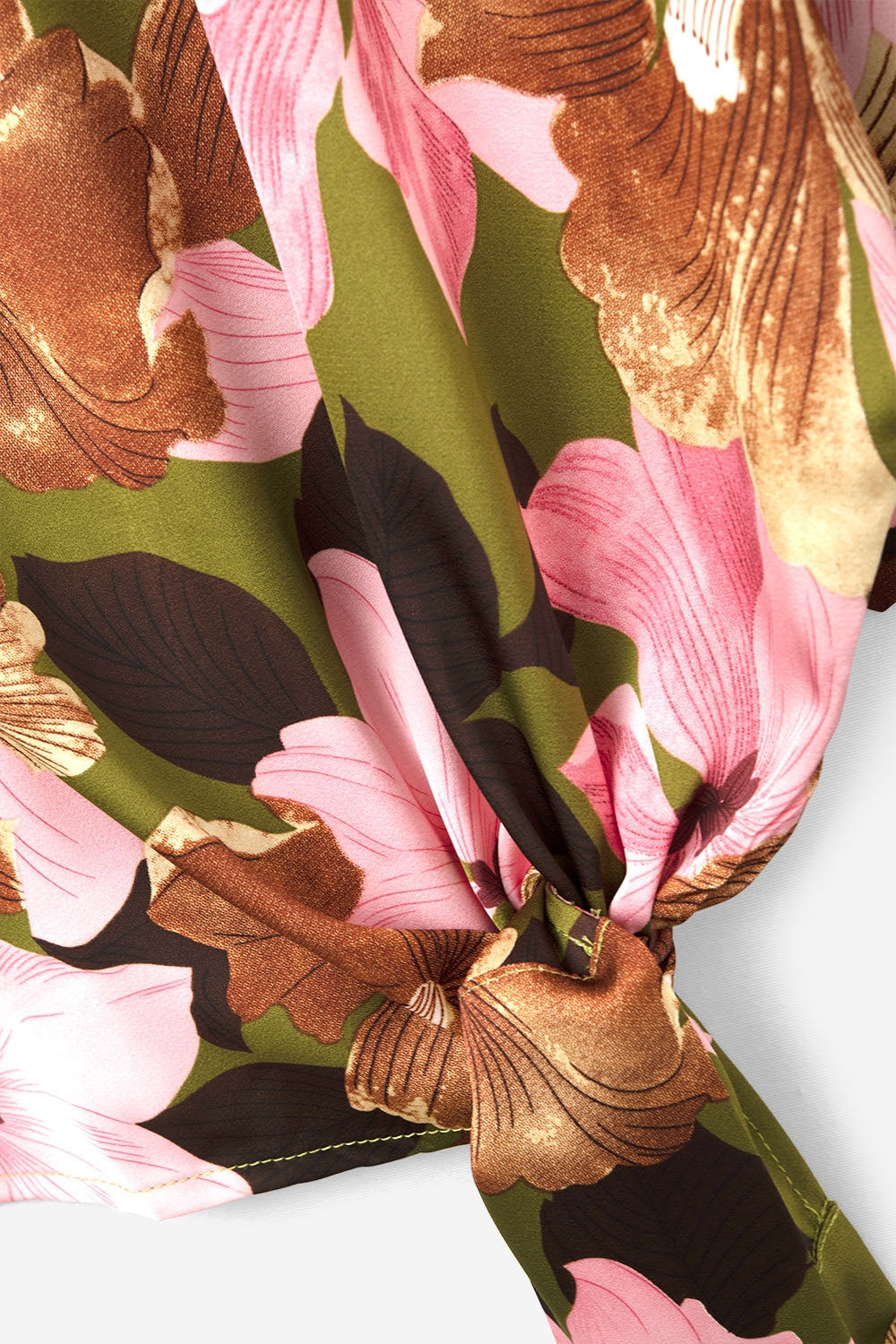 Top com nó floral e fundo verde em tecido acetinado