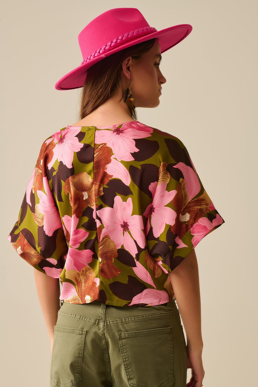 Top com nó floral e fundo verde em tecido acetinado