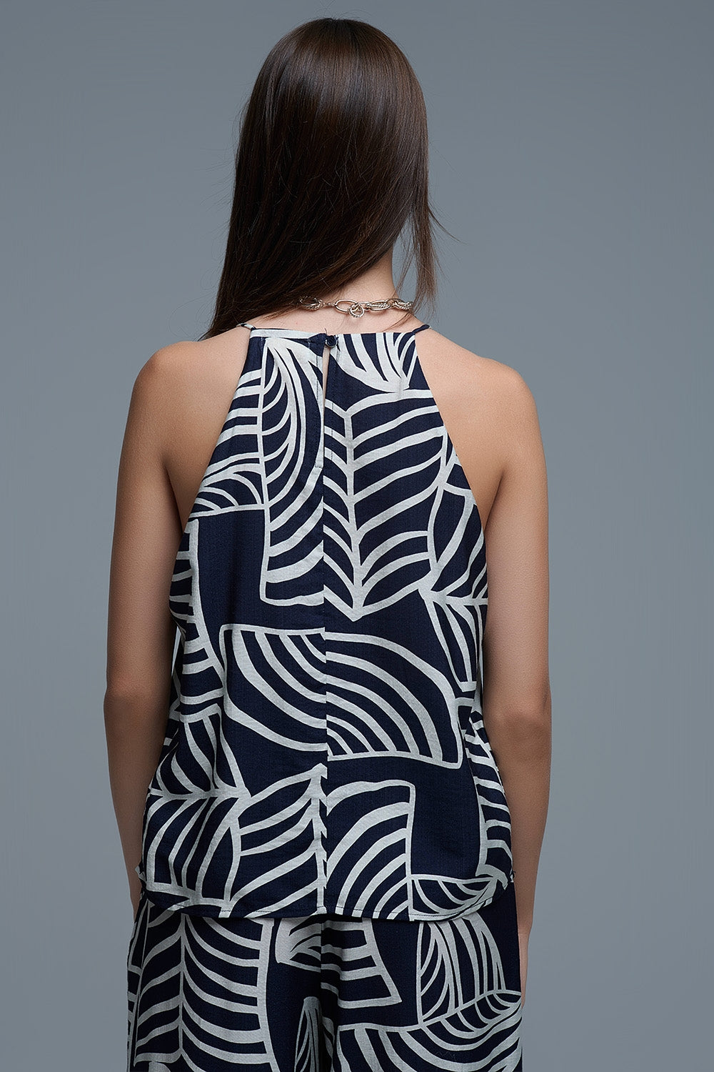 Top sem mangas em azul-marinho e branco com estampado de folhas brancas