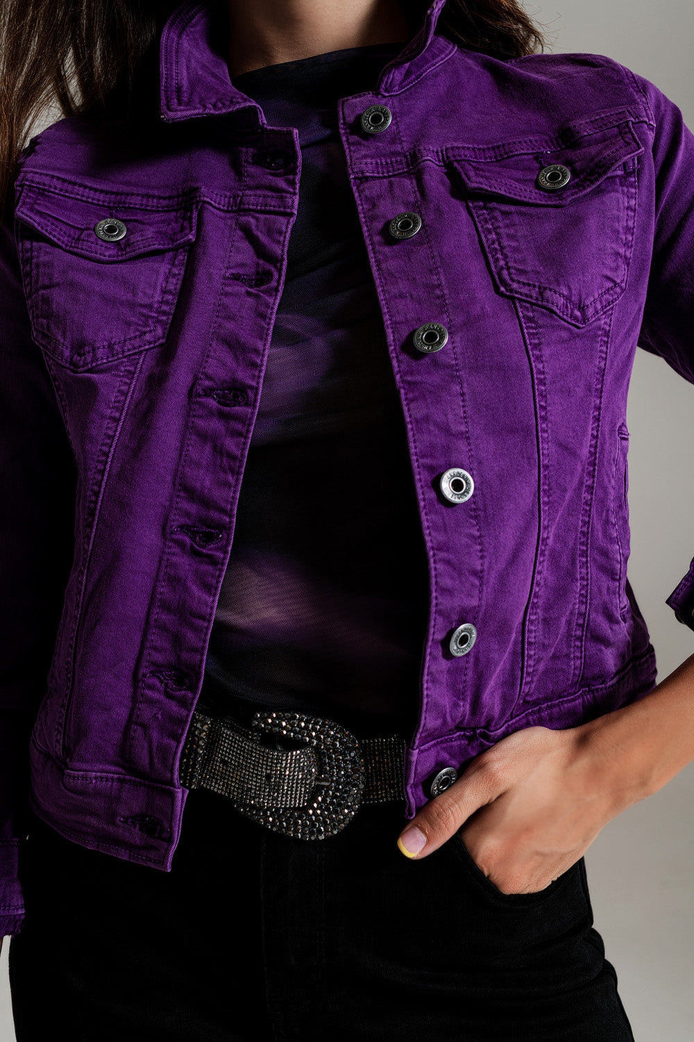 Fitted purple jean jacket with button closure and chest pockets worn with black pants