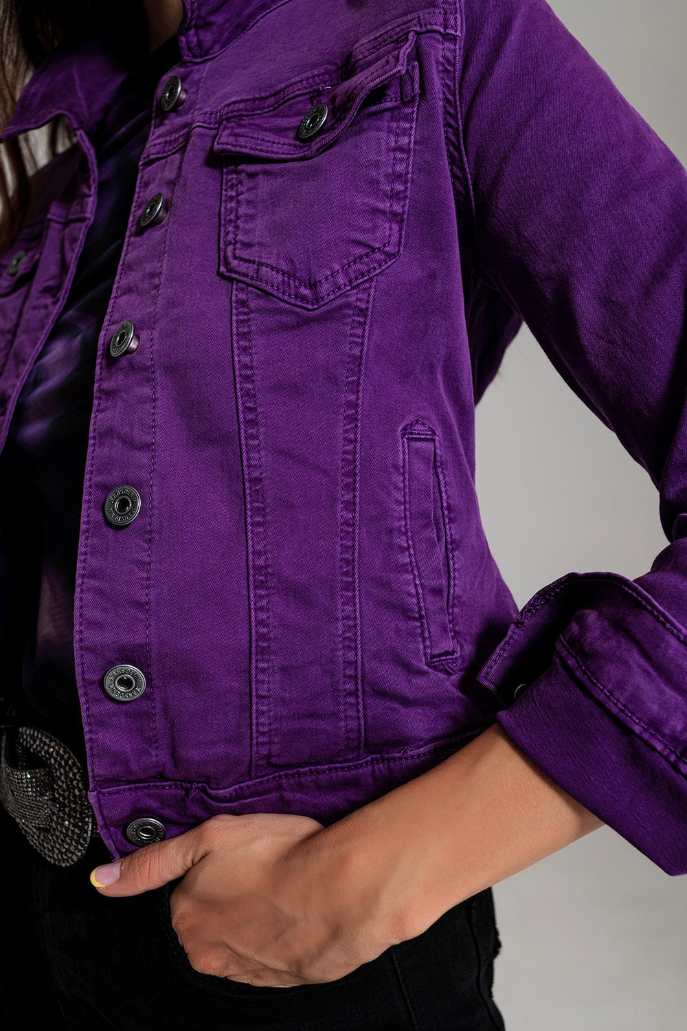 Fitted purple jean jacket with button closure and rolled sleeves on model