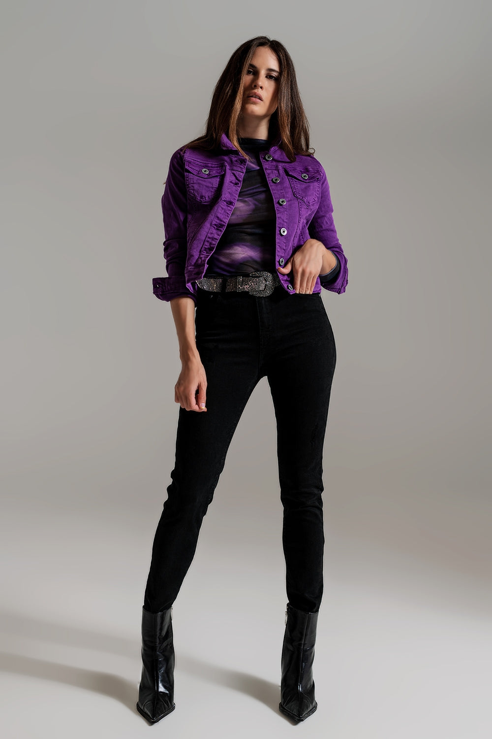 Model wearing fitted purple jean jacket paired with black jeans and ankle boots