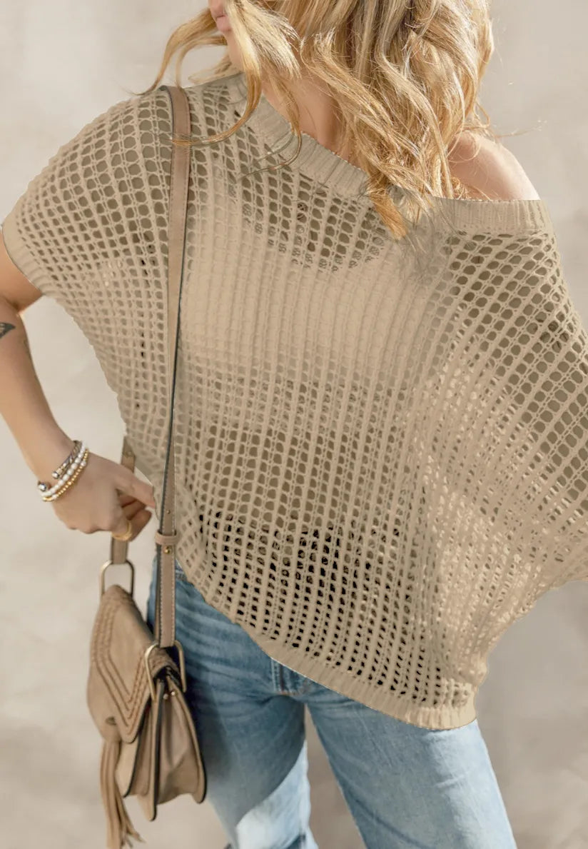 Beige knit beach cover up camisola with loose fit worn over jeans and accessorized with a tan handbag