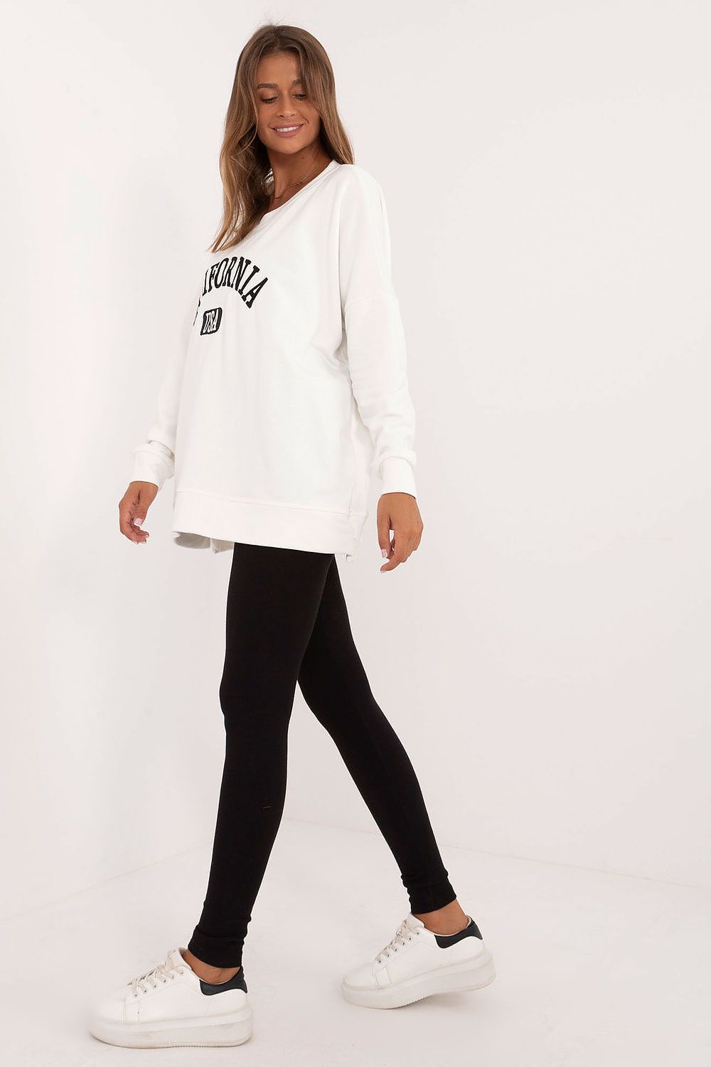 Woman wearing oversized sweatshirt and leggings set in white and black from Factory Price