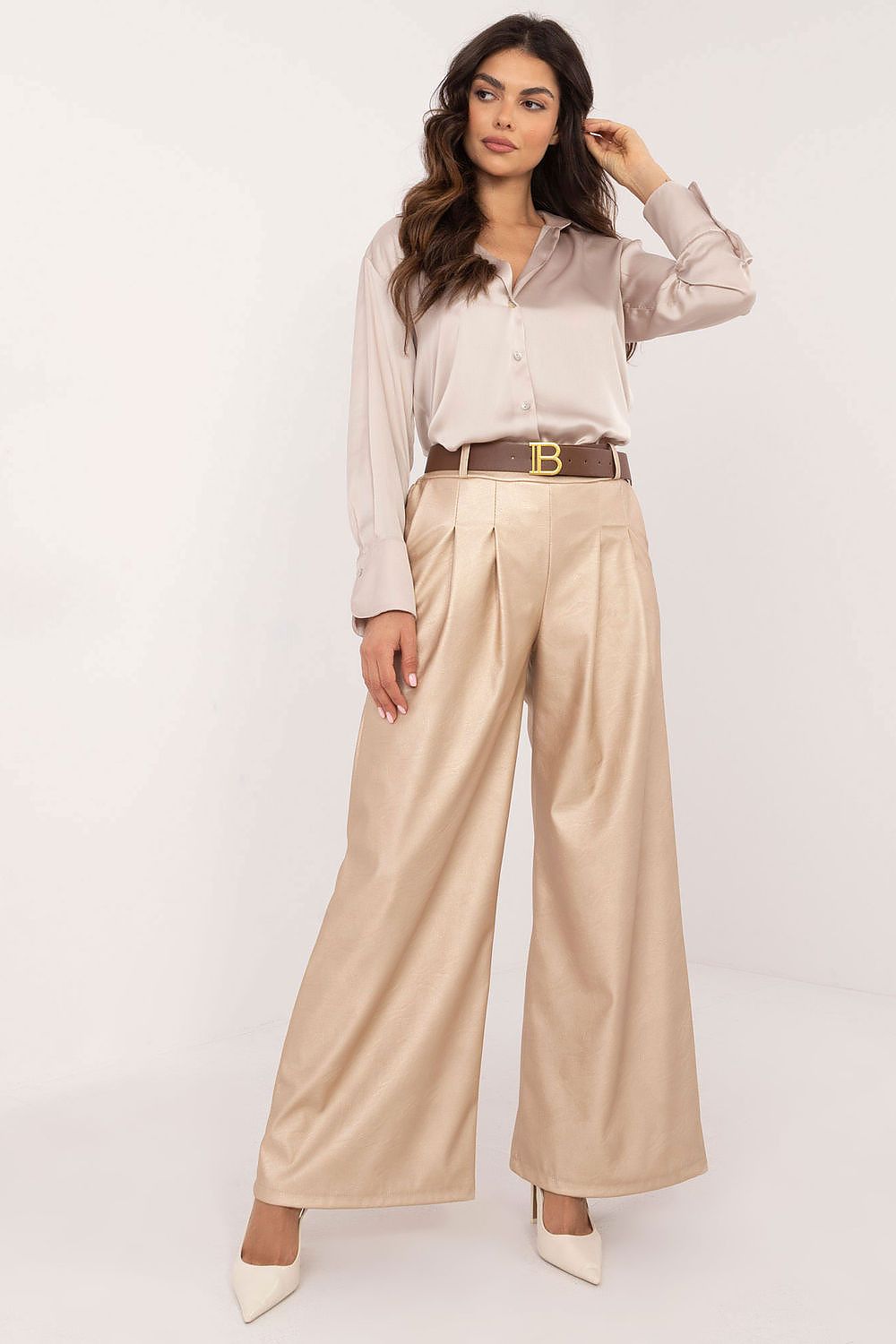 Woman wearing wide leg faux leather trousers in beige by Italy Moda paired with a satin blouse and heels