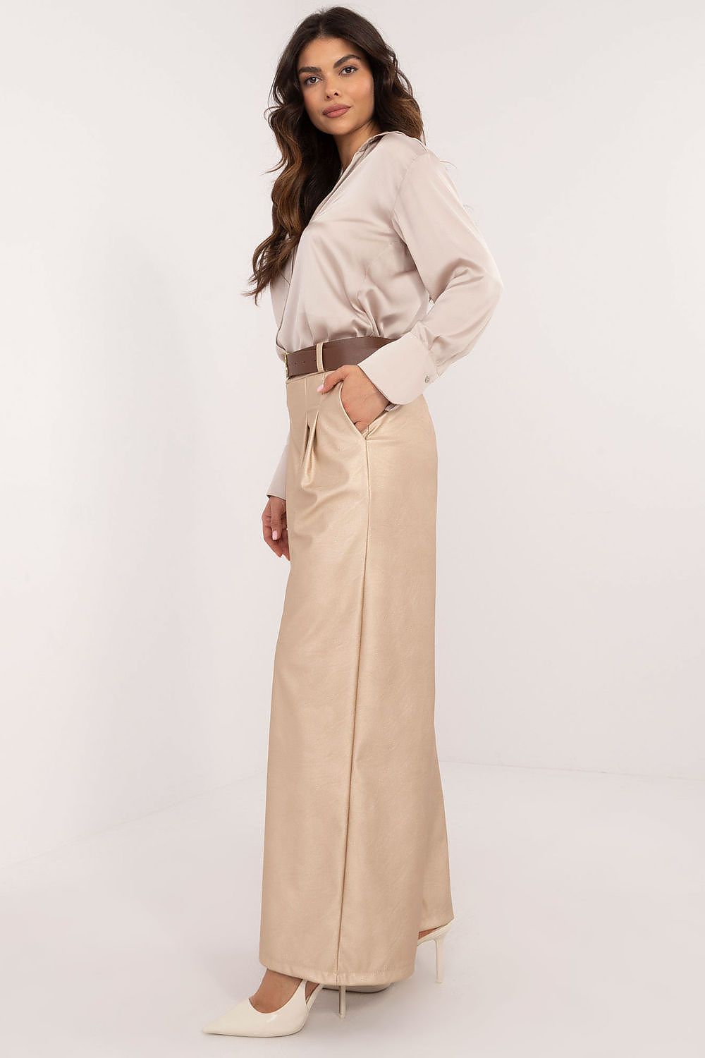 Woman wearing beige wide leg faux leather trousers by Italy Moda paired with a light blouse and heels