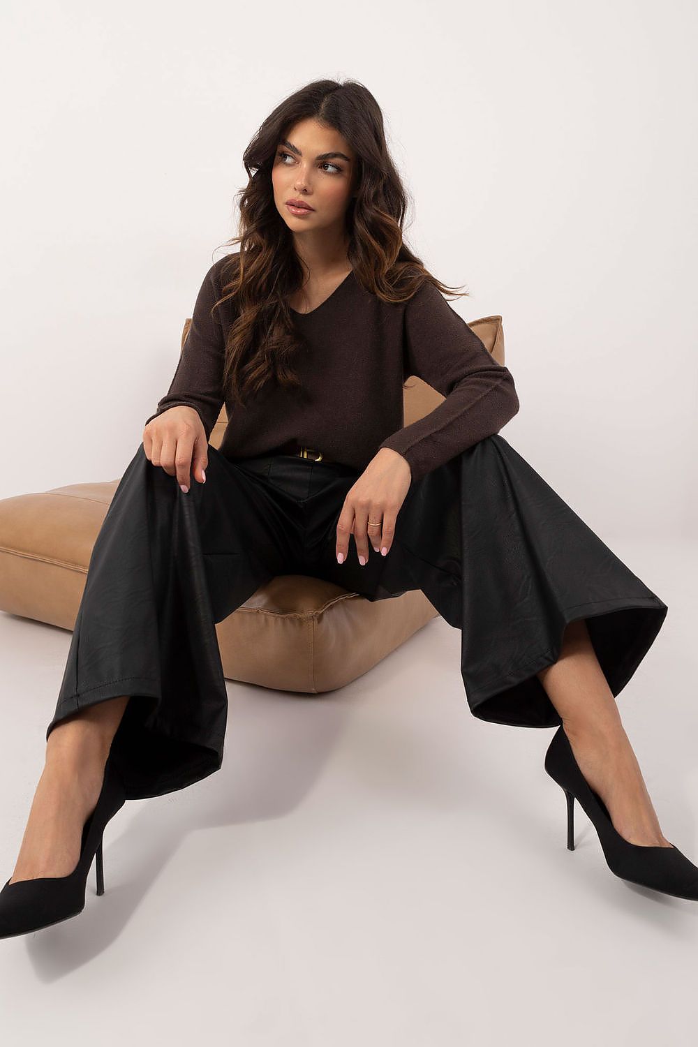 Woman wearing Italy Moda wide leg faux leather trousers paired with a brown long sleeve top and black heels