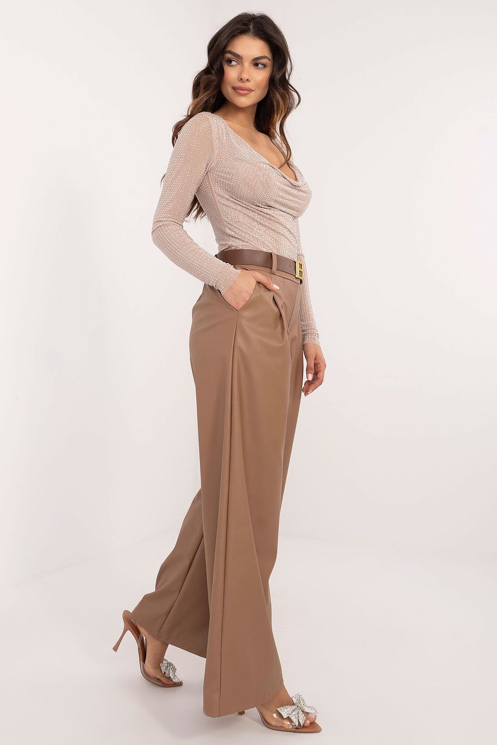Woman wearing Italy Moda wide leg faux leather trousers in brown with beige top and heels