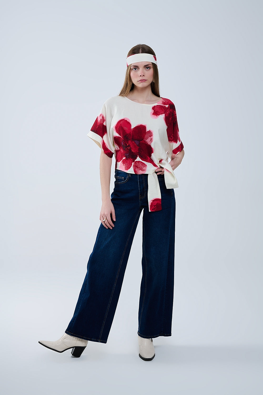 Blusa bege cortada com estampado floral tropical em vermelho atado na cintura