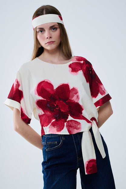 Blusa bege cortada com estampado floral tropical em vermelho atado na cintura