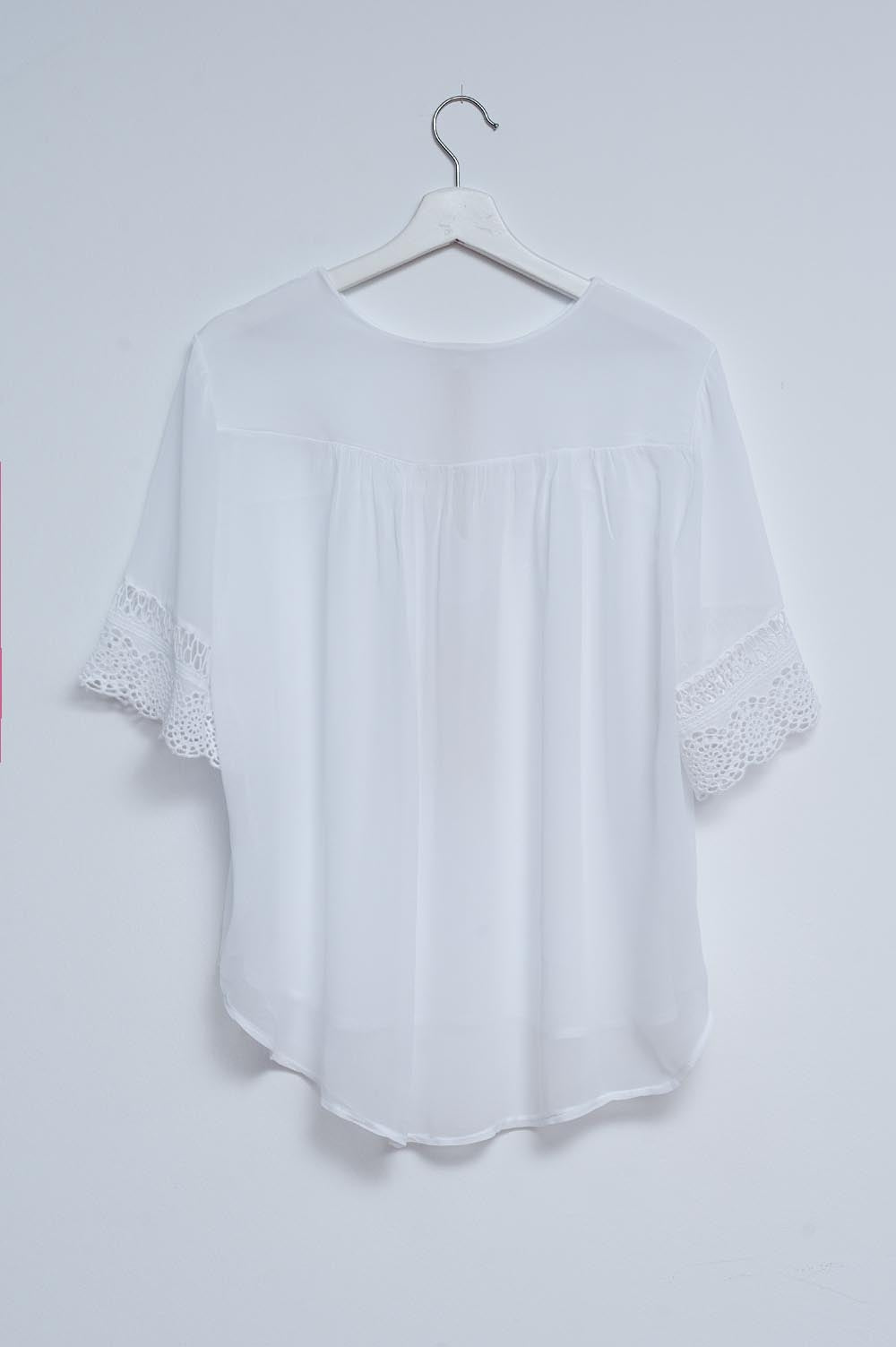 Blusa branca com renda na frente e bordados