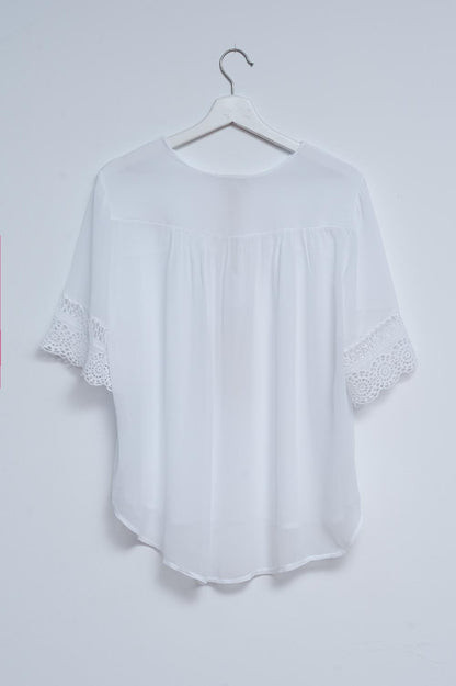 Blusa branca com renda na frente e bordados