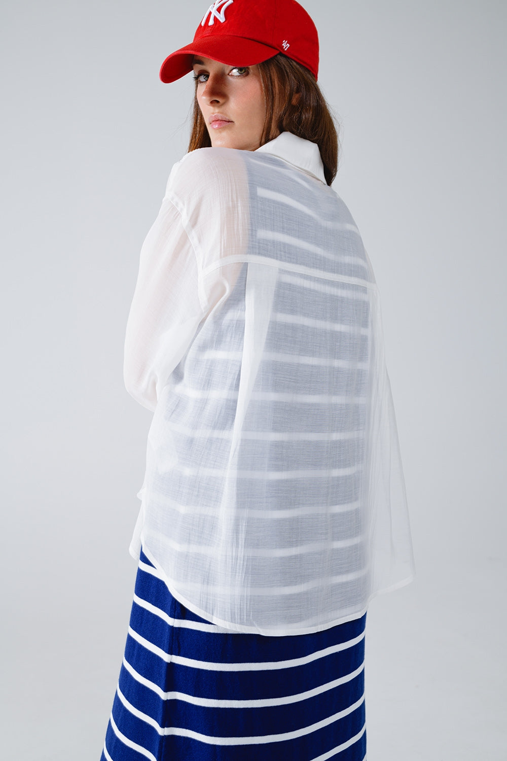 Blusa branca semi-transparente com detalhes de folhos na frente