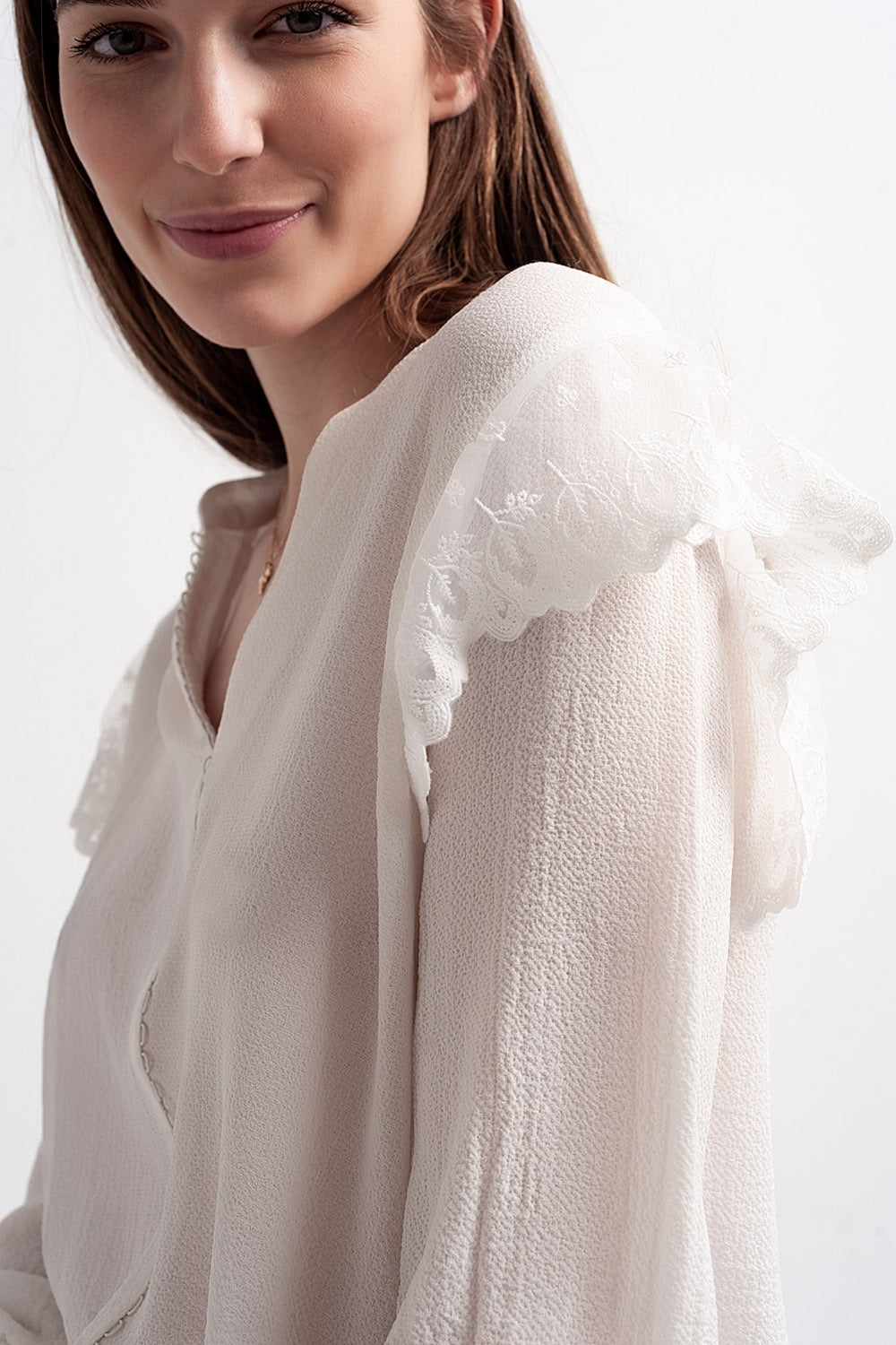 Blusa com volume nas mangas e rufos nos punhos em cor creme.