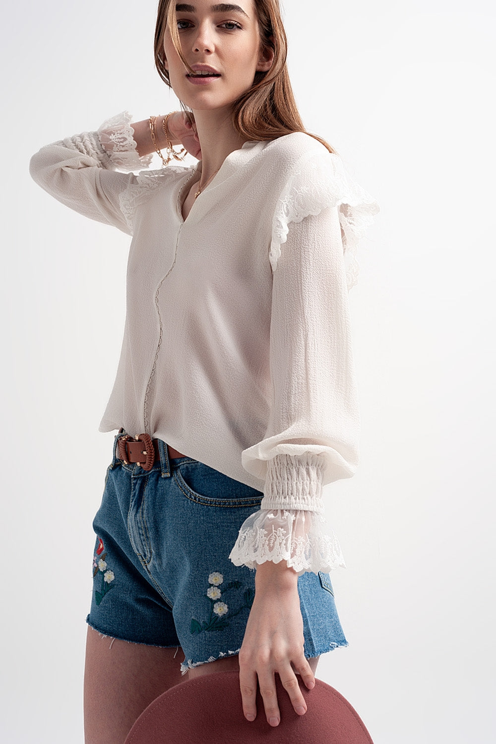 Blusa com volume nas mangas e rufos nos punhos em cor creme.